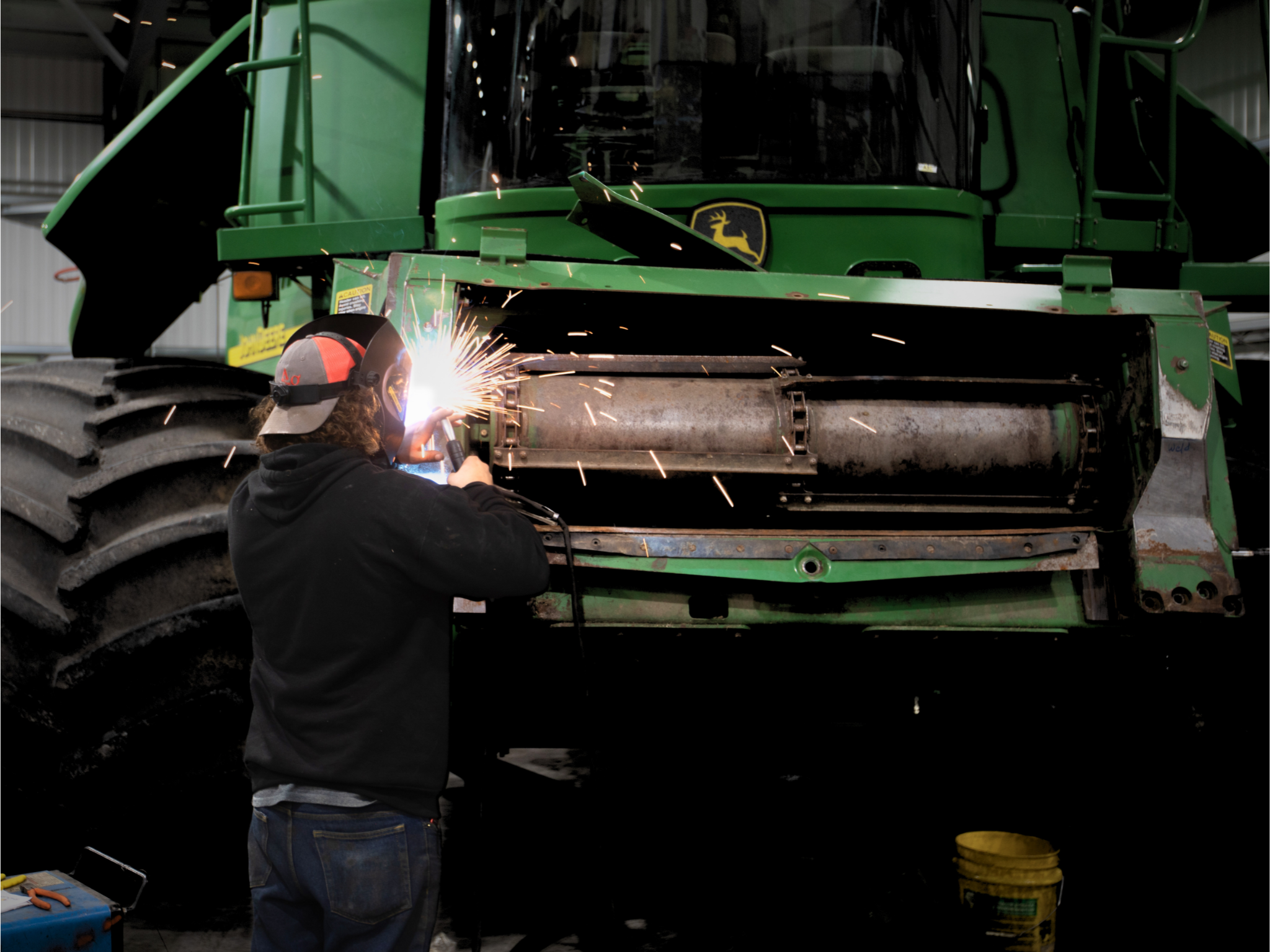 A welding student is working on the front section of the machine.