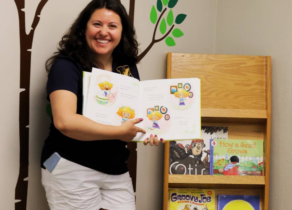 Student holds a book open for storytime