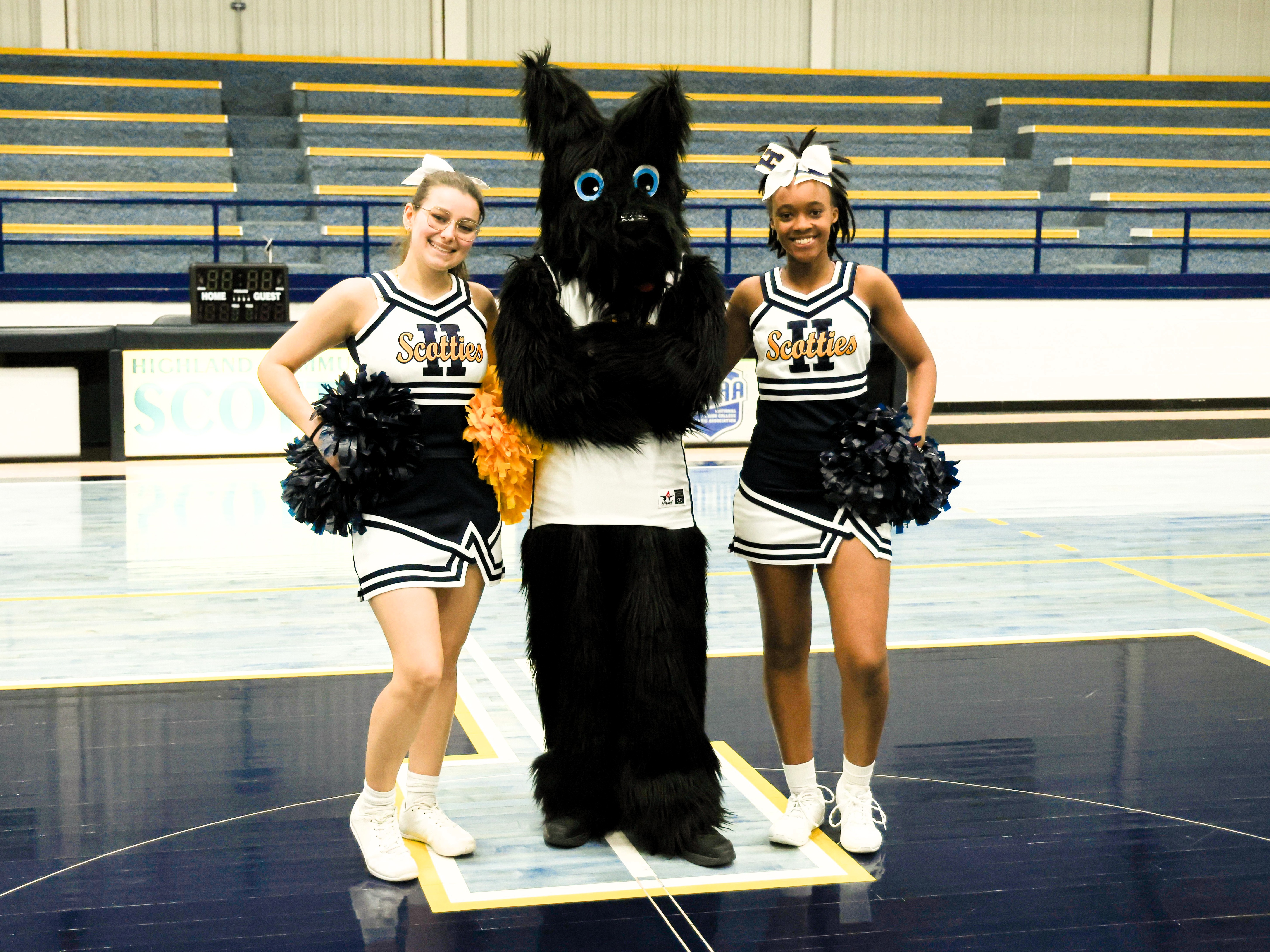 Two Spirit Squad Athletes pose with Scottie Mascot
