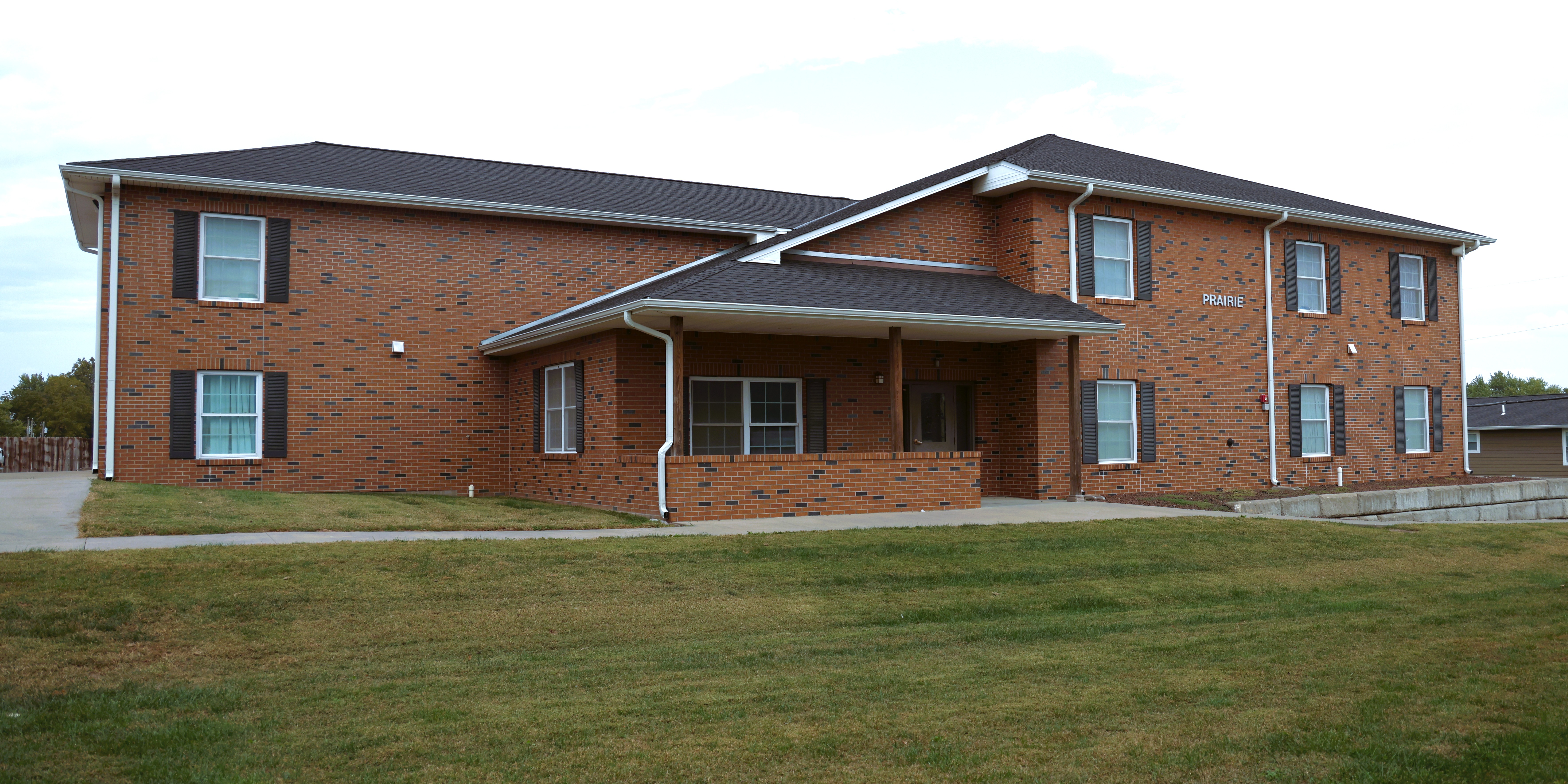 Outside view of the front of Prairie Dorm, a long brick building.