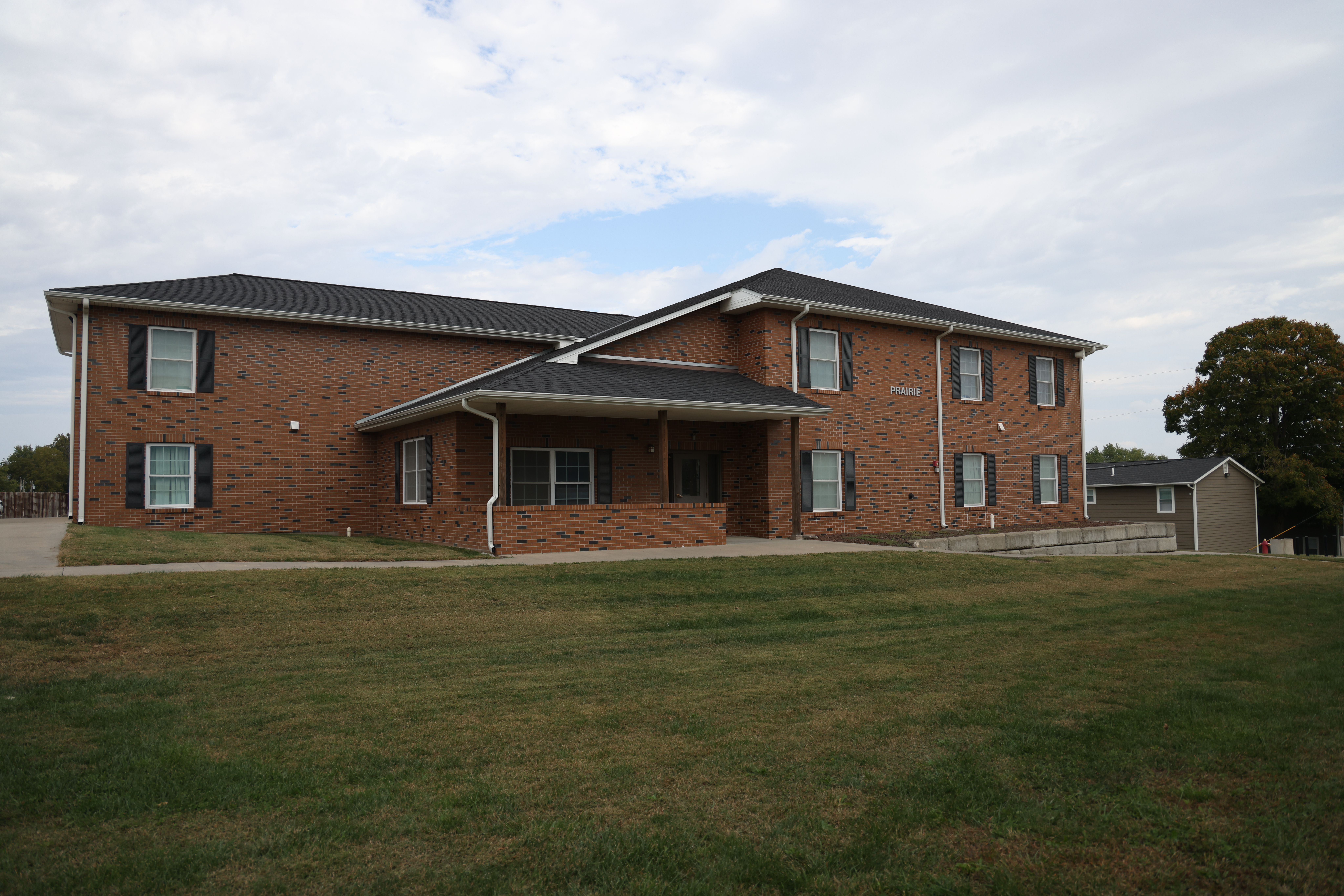 Outside view of the front of Prairie Dorm, a long brick building.