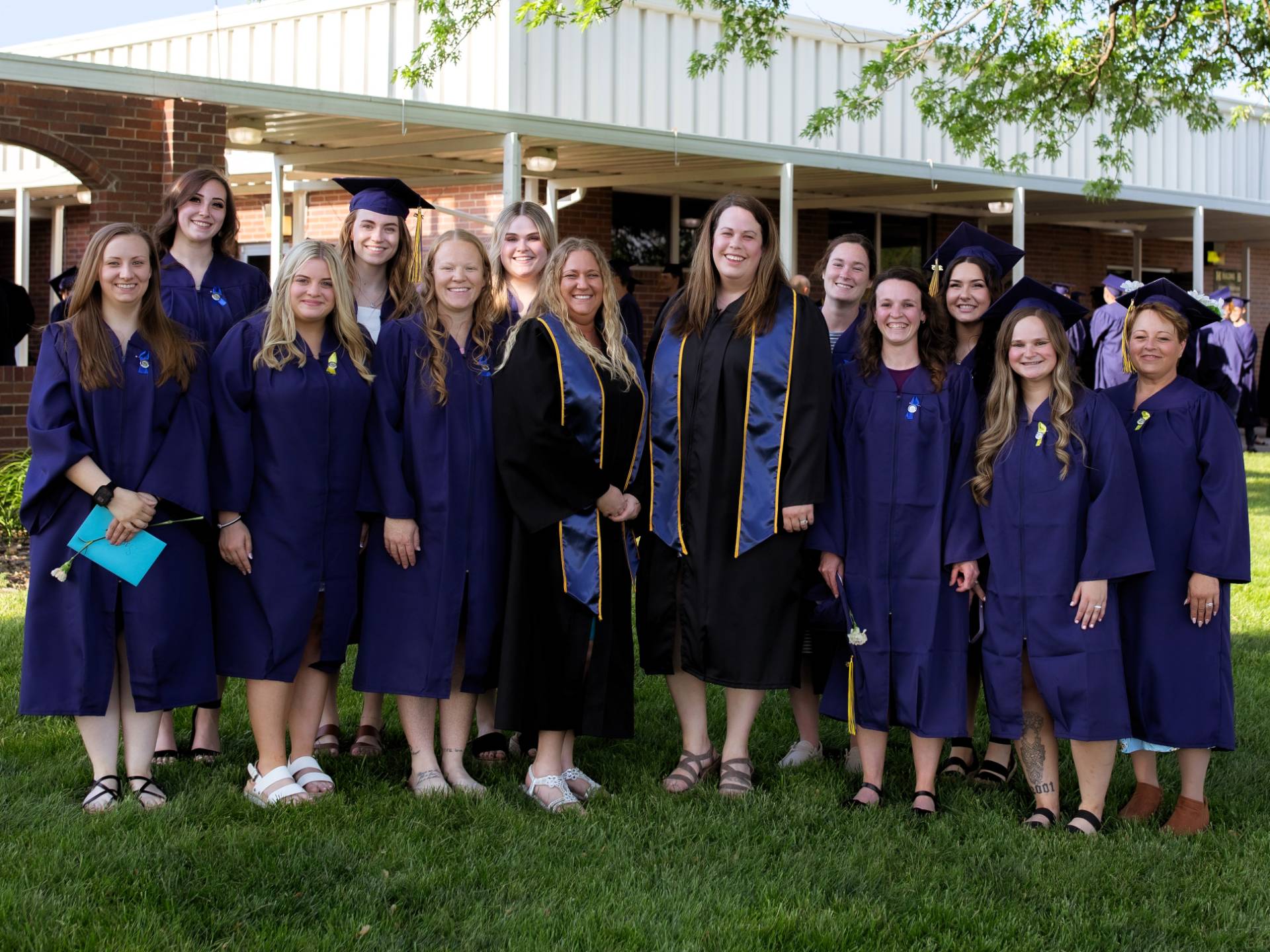 Students in the technical center at graduation pose outside.